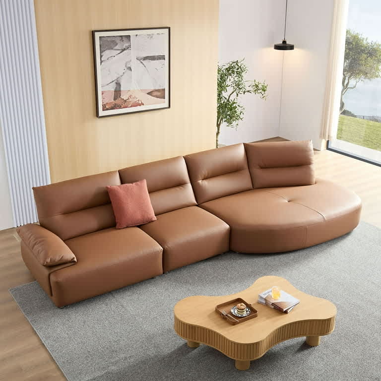 Modern curved eco-leather sectional sofa in a stylish living room setting with complementary furniture and decor