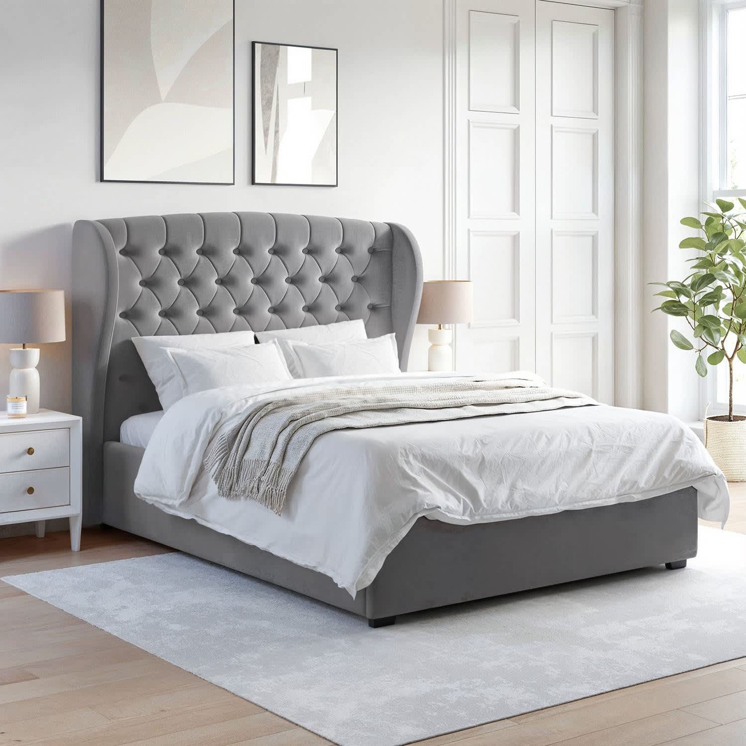 Modern bedroom featuring a grey velvet king-size ottoman bed with a tufted winged headboard and complementary white furniture