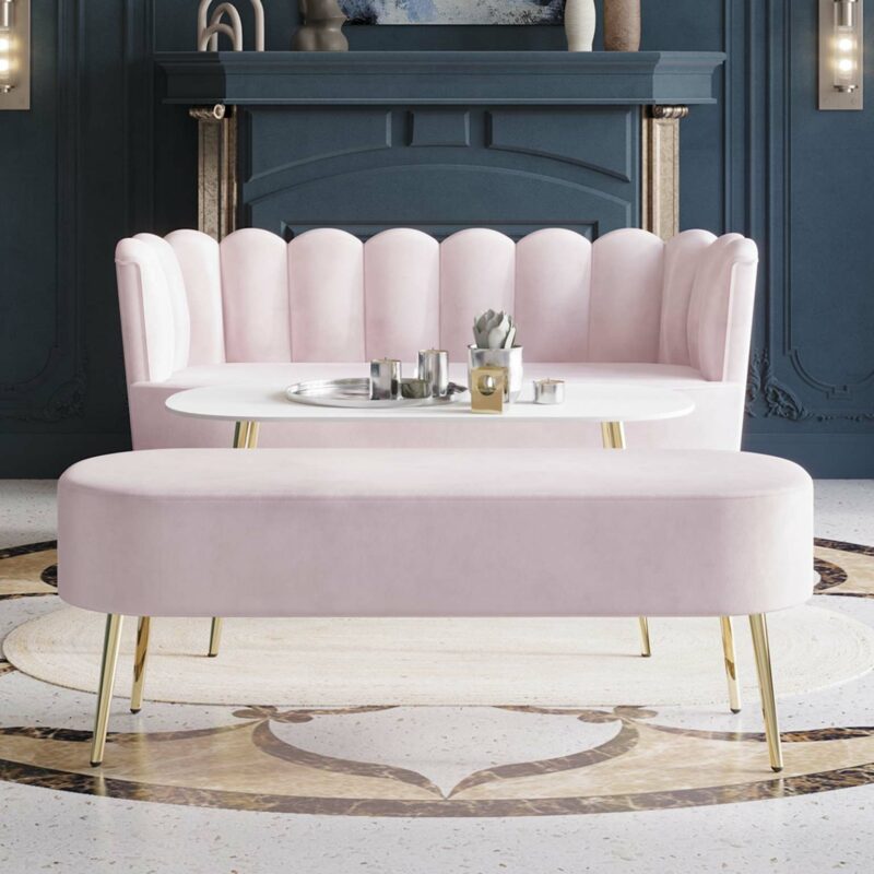 Luxury pink velvet upholstered loveseat and bench with gold legs in a stylish living room setting