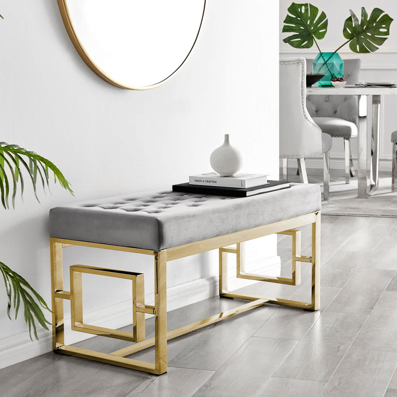 Luxury grey velvet upholstered bench with gold frame in a modern interior setting