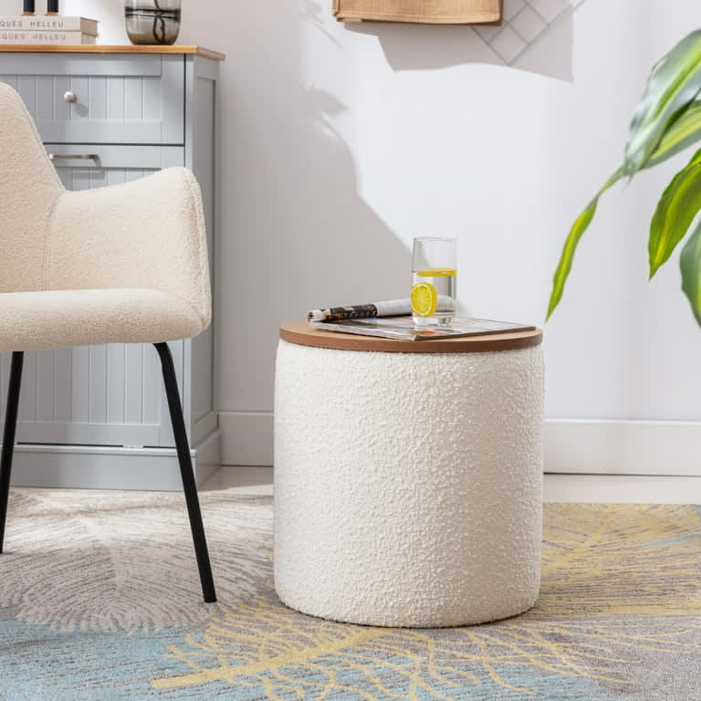 A stylish white boucle footstool with a wooden tray lid in a cozy living space corner, illustrating handcrafted comfort and modern elegance