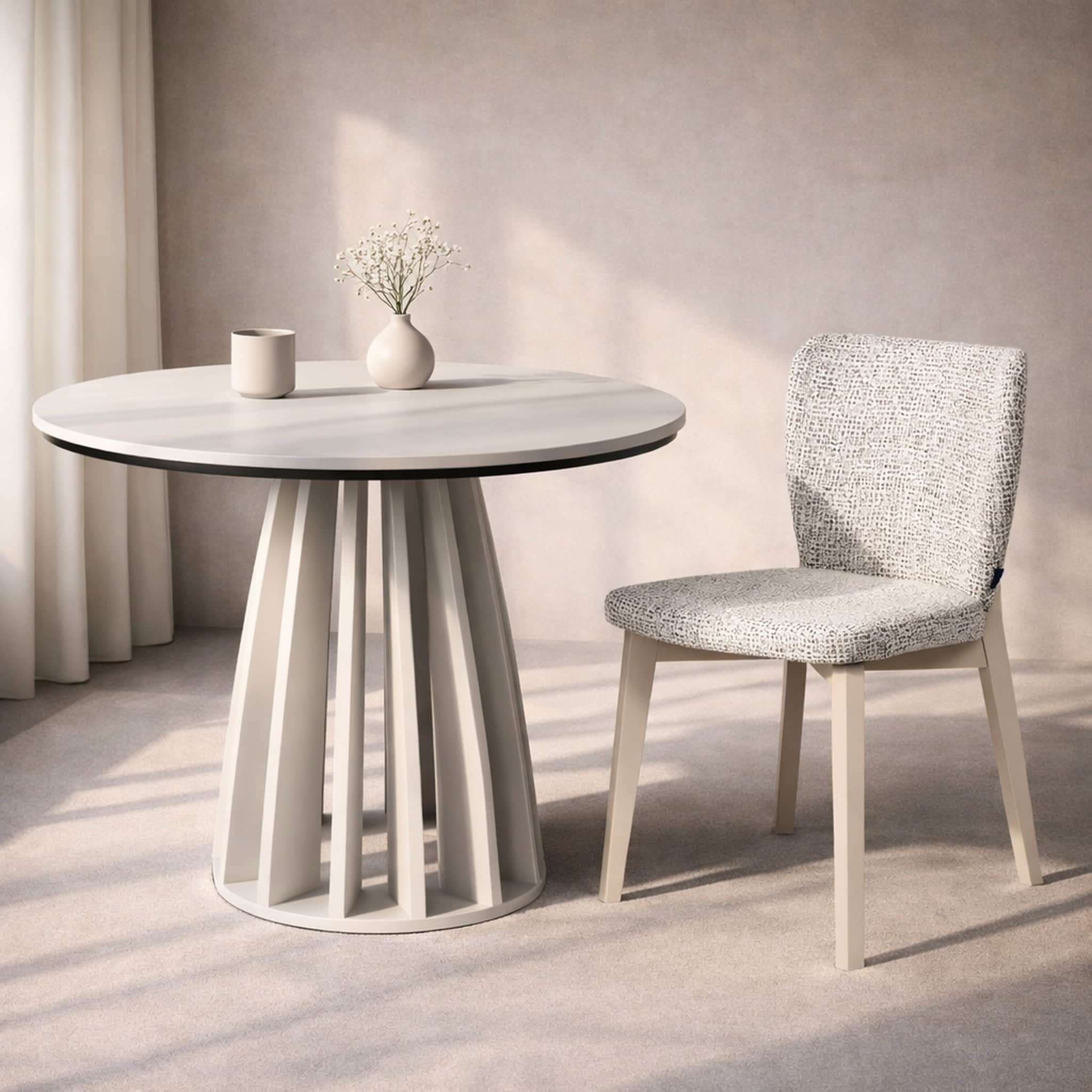 Modern white round table with vase and chair in minimalist interior setting.