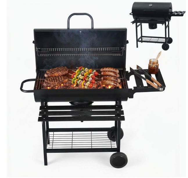 Grill with steaks and vegetables on a black barbecue, with a small side grill and utensils for outdo.