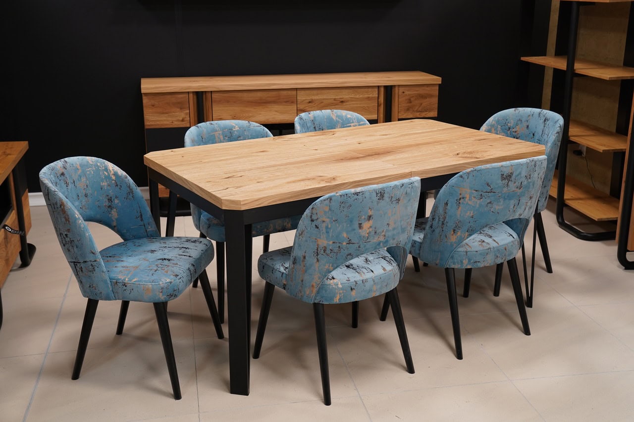 Modern wooden dining table with six upholstered blue chairs in a contemporary setting.