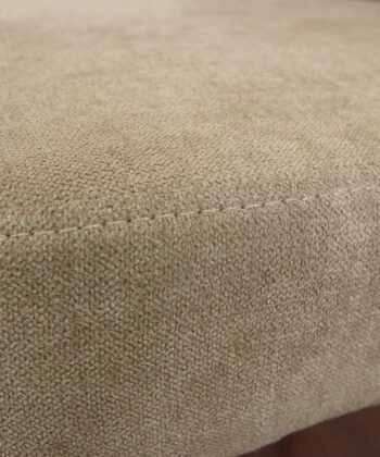 Soft beige fabric pouffe with textured upholstery, ideal for modern living room decor.