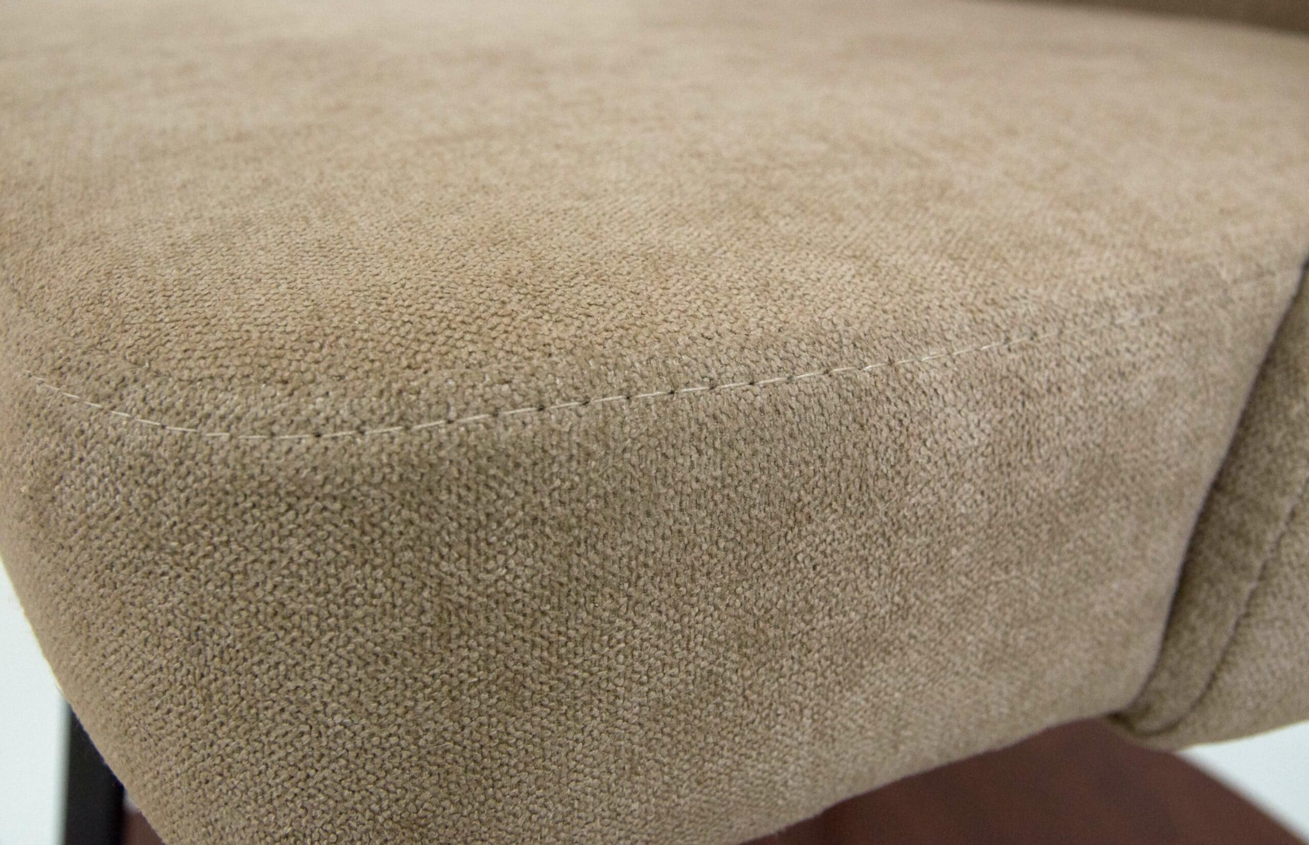 Soft beige fabric pouffe with textured upholstery, ideal for modern living room decor.