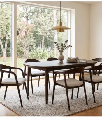 Modern dining room with wooden table and stylish chairs near large window.