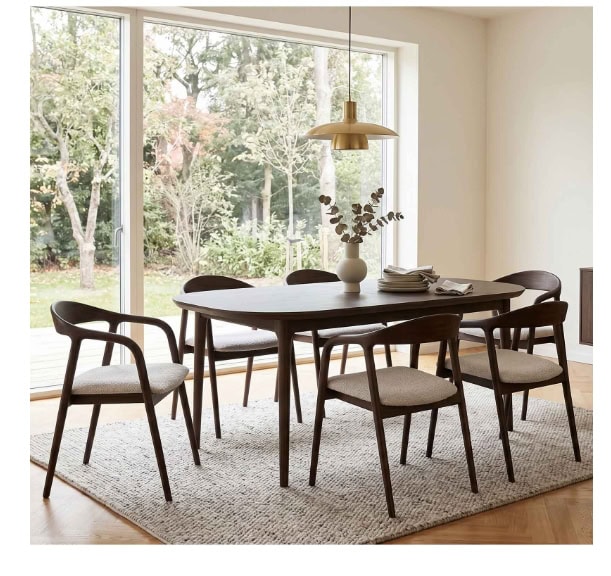 Modern dining room with wooden table and stylish chairs near large window.