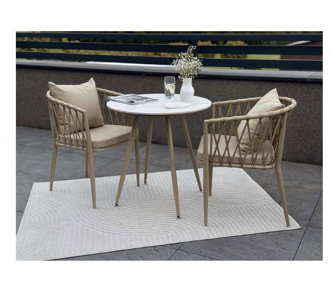 Modern outdoor patio furniture with a round table and two woven chairs on a balcony.