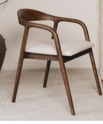 Modern wooden armchair with beige cushion in stylish interior setting.