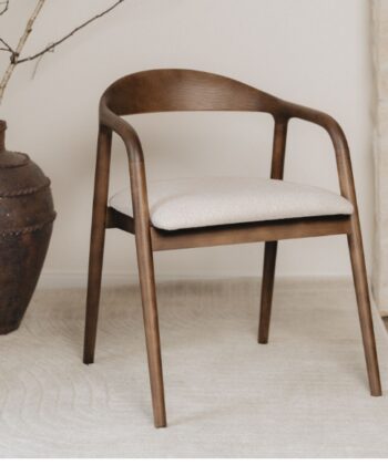 Modern wooden chair with beige cushion in minimalist interior setting.
